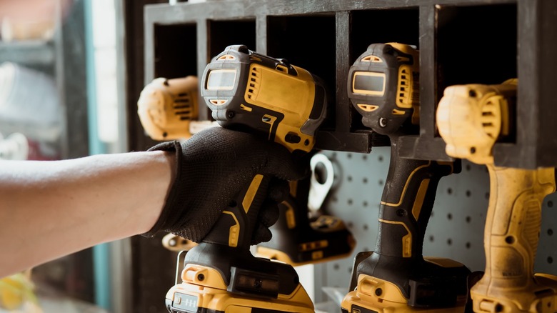 person reaching for power tool