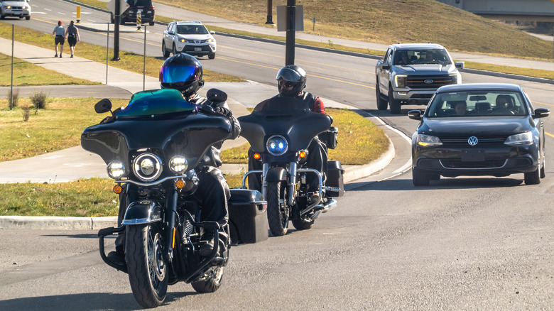 Motorcycles and cars driving on road