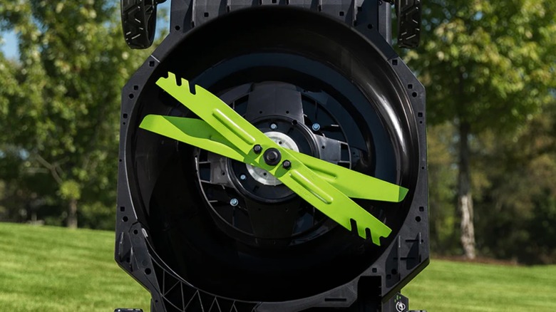 An Ego lawn mower flipped up revealing the blades.