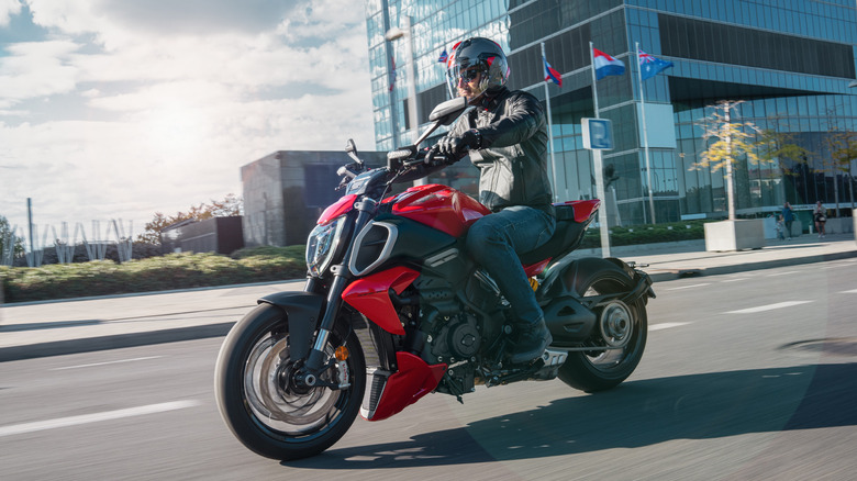A person riding a Ducati Diavel V4 on city streets