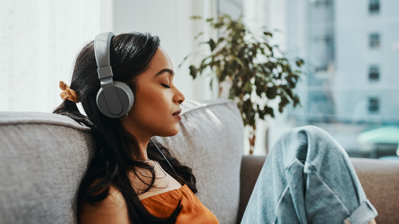 woman wearing headphones on couch