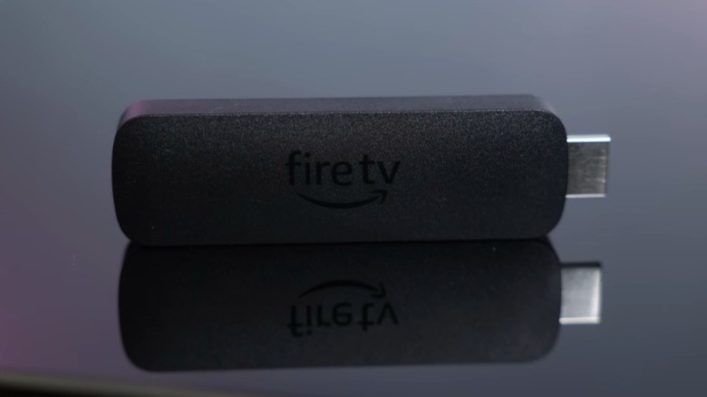 Amazon Fire TV Stick 4K Max on a black reflective surface