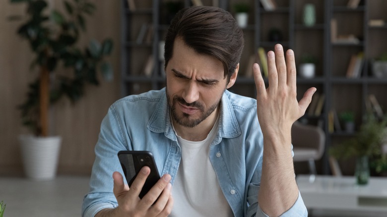 A man frustrated at his phone. 