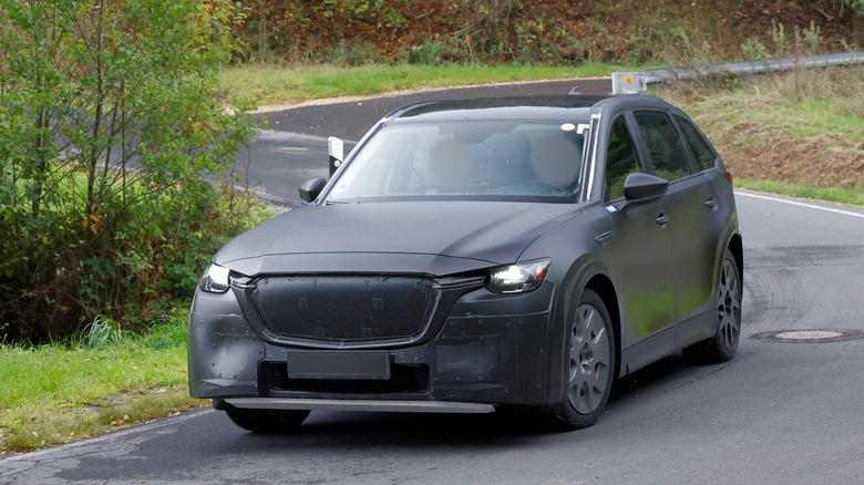 A gray Mazda chassis-testing-mule spotted on a curve at a Mazda testing facility