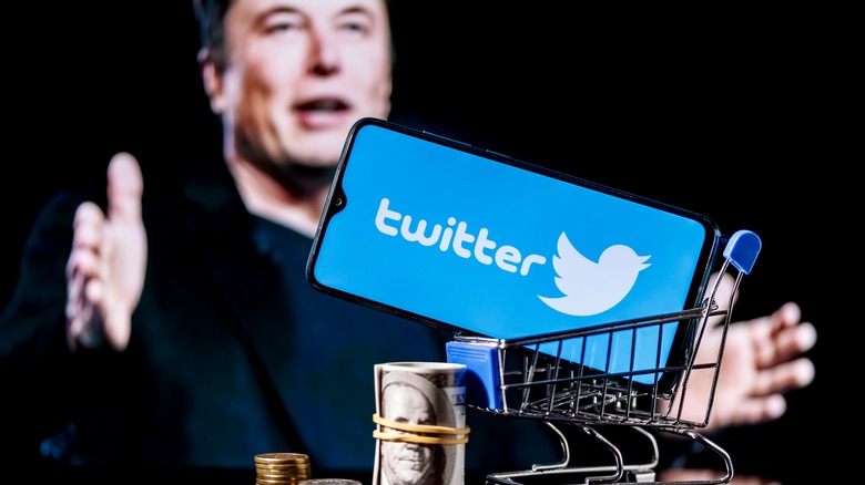 Elon Musk in background of phone with Twitter logo