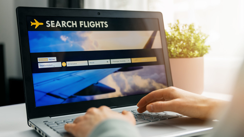 Person using a laptop to look for available flights