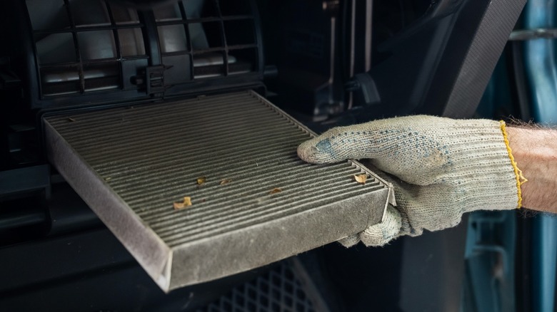 A person replacing a car's cabin air filter