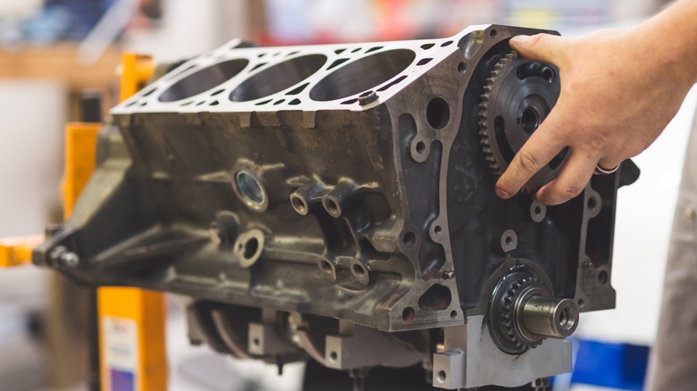A bare V6 engine block being repaired.
