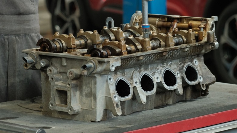 A cylinder head being repaired on a work bench.