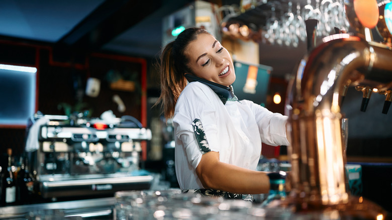 A bartender talking on phone