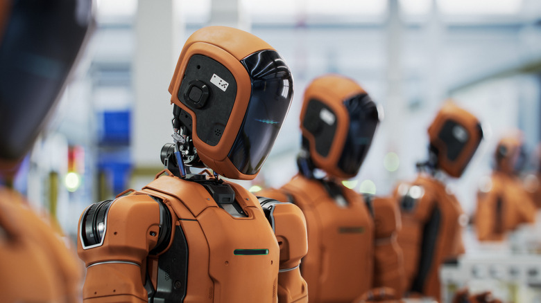 Row of humanoid robots. on an assembly line