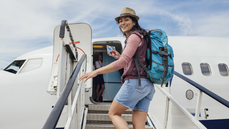 woman with backpack getting on a plane