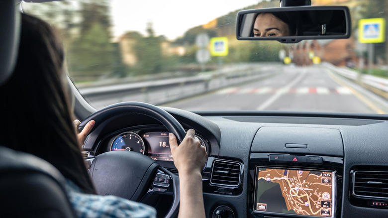 Woman driving a car with hands on the wheel