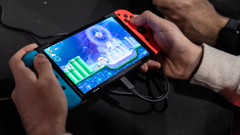 A man playing on a Nintendo Switch OLED.