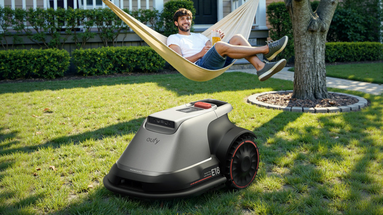 Eufy robotic lawn mower with man in hammock in background