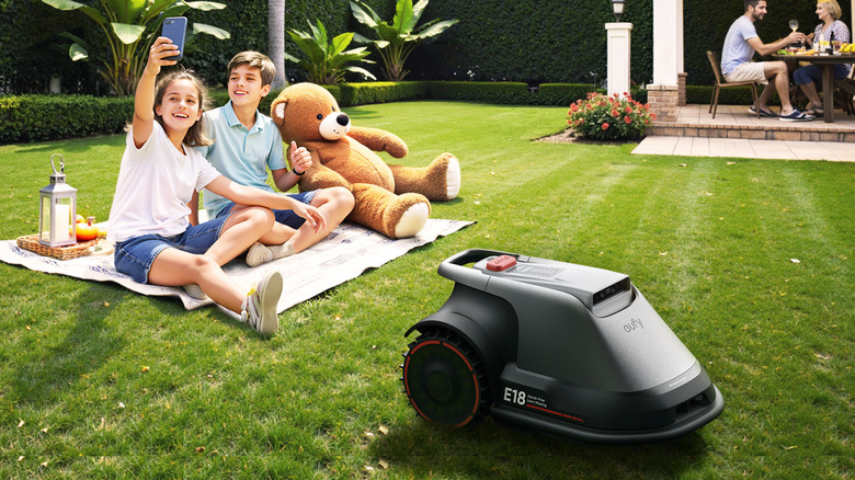 Eufy robotic lawn mower with kids in background