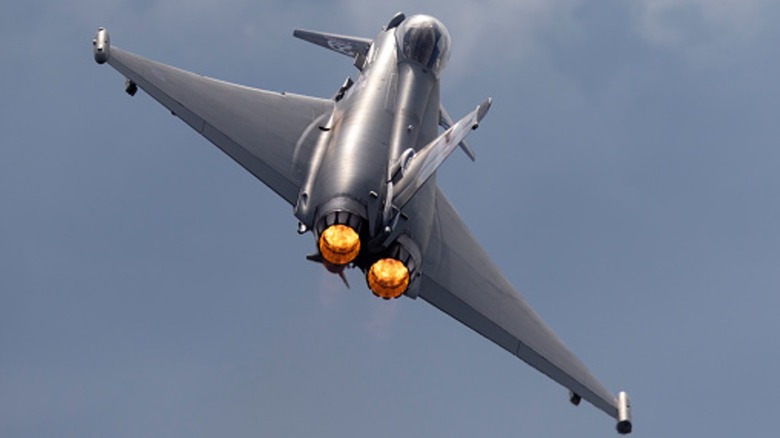 Eurofighter Typhoon from behind, flying upward with its afterburners engaged