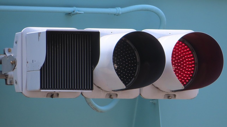 A traffic light with the green signal covered by a louvre