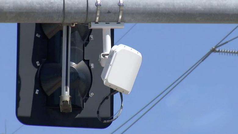 White square box hanging by traffic light