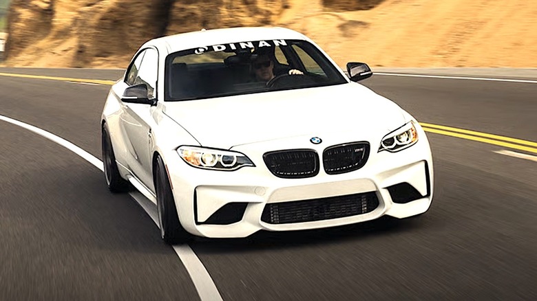 Person driving BMW with Dinan auto sticker on windshield