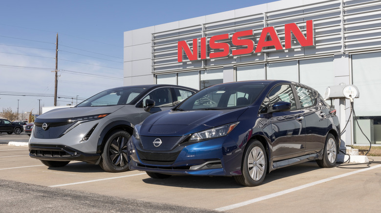 Nissan Leaf and Ariya EVs parked outside a Nissan dealership