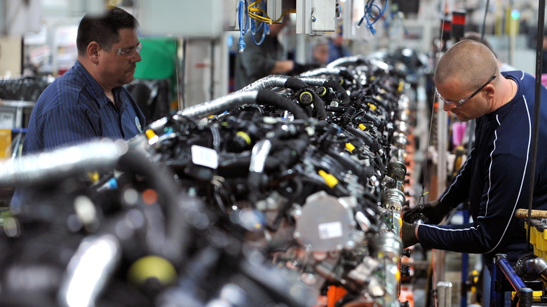 men working on engine assembly line