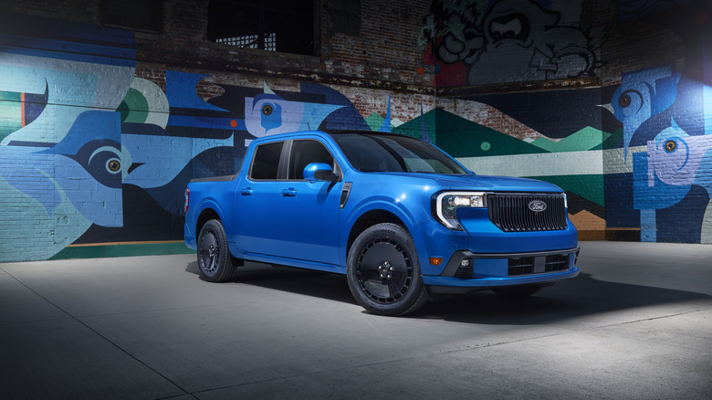 Blue 2025 Ford Maverick Lobo lickup seen from right front parked against a backdrop of abstract murals