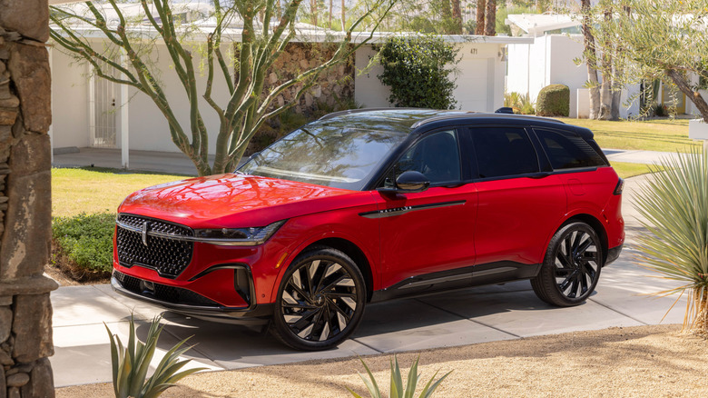 Red Lincoln Nautilus SUV seen from left front parked in a driveway