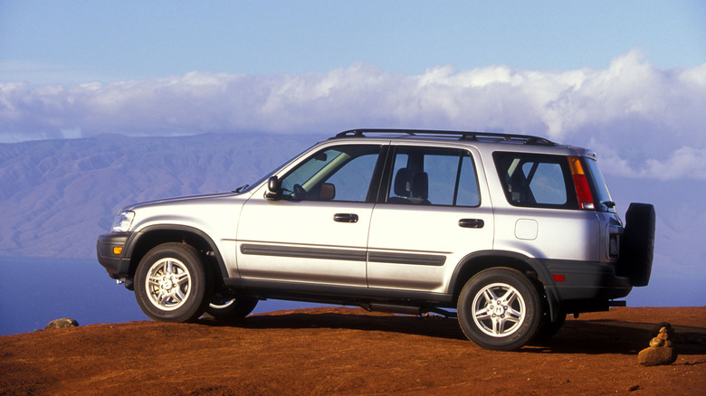 A silver first-generation Honda CR-V parked on a cliffside.