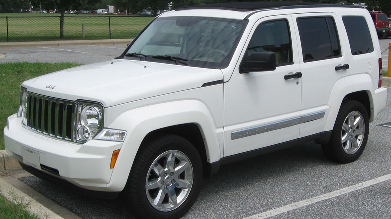 A white fourth generation Jeep Liberty in a parking spot