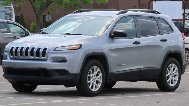 A gray Jeep Cherokee fifth generation in a parking spot