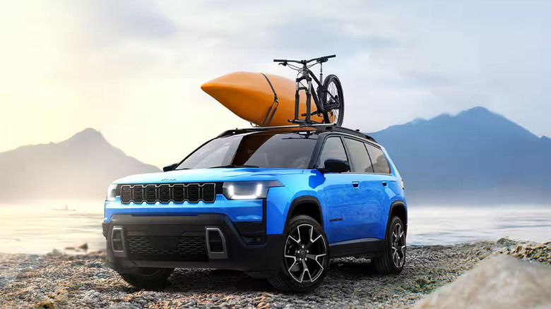 A picture of a blue and black Jeep Cherokee with a kayak