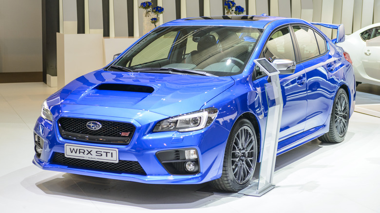 A blue Subaru WRX STI on a showroom floor