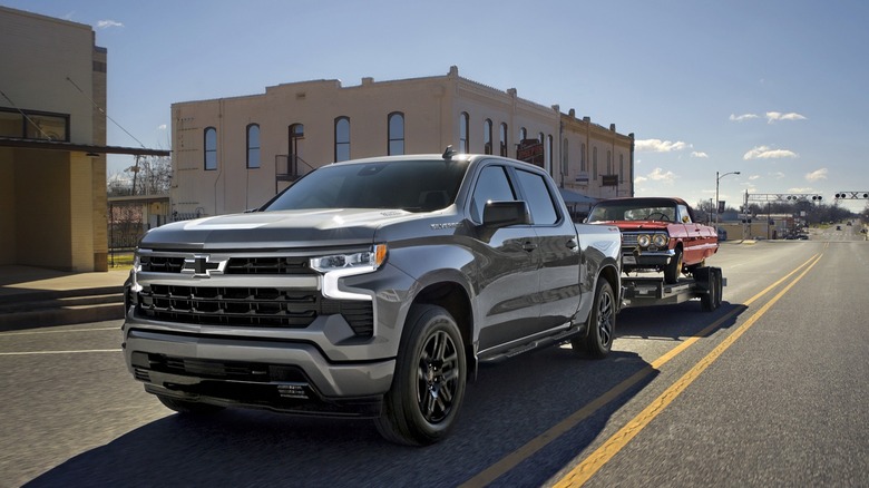 2026 Chevrolet Silverado 1500 RST Shown In Sterling Gray Metallic Towing A Vintage Car