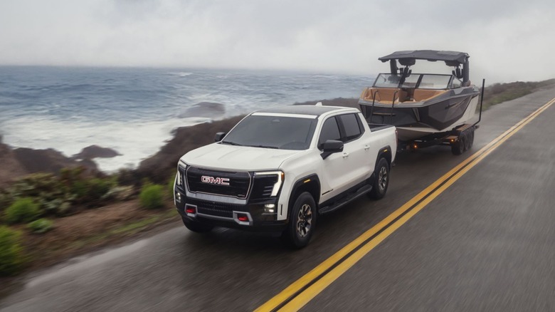 2026 GMC Sierra EV AT4 Shown In Summit White Towing A Boat