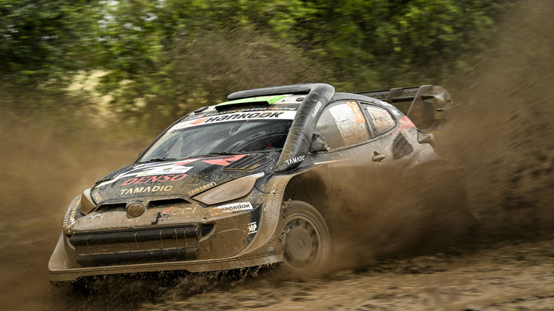 Toyota GR Yaris rally car drifting on a muddy surface