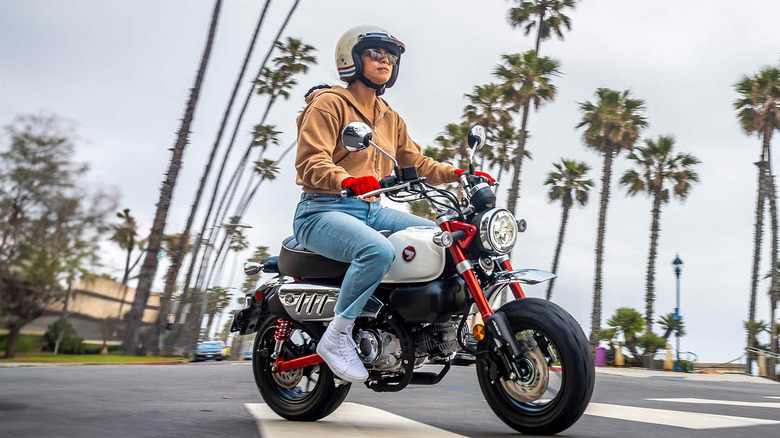 A rider in full gear on a Honda Monkey ABS with sunglasses on.