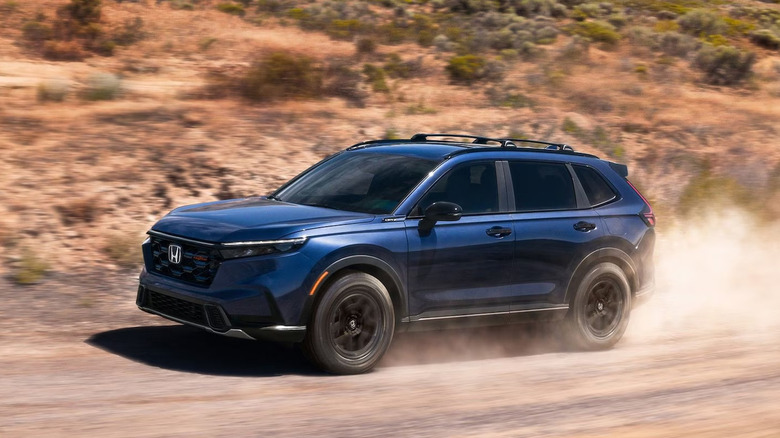 A blue Honda CR-V driving along a dirt road