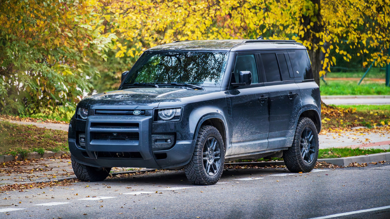 A black Land Rover Defender 110 off-road SUV parked on a street