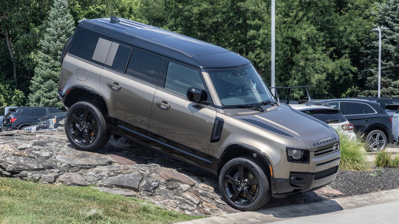 A 2025 Land Rover Defender 110 in grey paint making its way onto a road