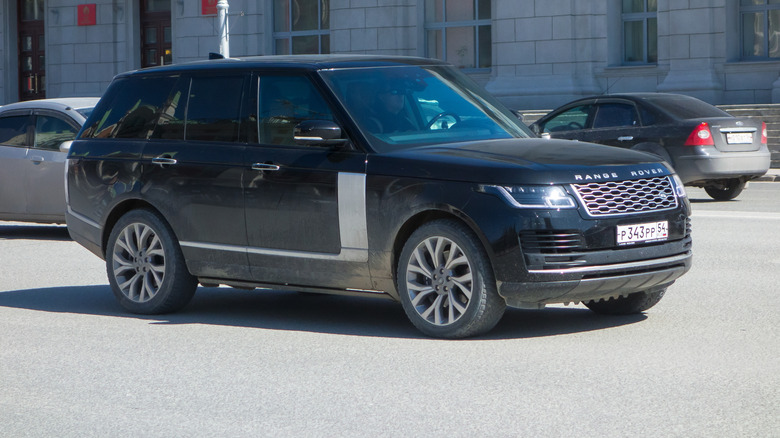 A range Rover standard wheelbase luxury SUV driving through a city