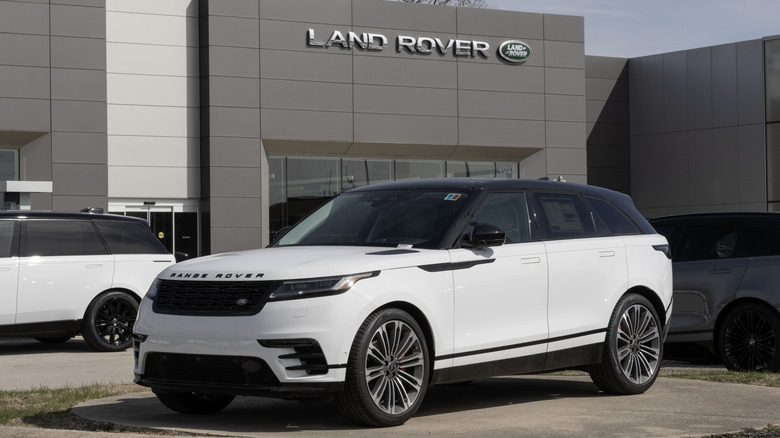 A white Range Rover Velar Dynamic SE on display in front of a Land Rover dealer