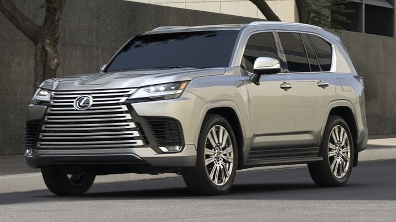 2025 Lexus LX parked next to a building with trees in the background