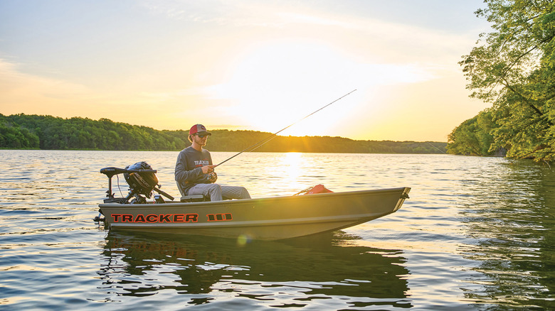 A man fishing in a Grizzly 10 Jon fishing boat at sunrise