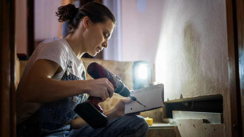woman using cordless drill on wood