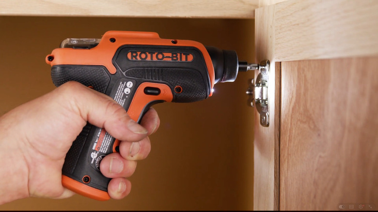 the Black and Decker Roto-bit power screwdriver used on a cabinet door.