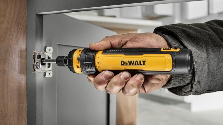 A DeWalt power screwdriver used on a cabinet door.