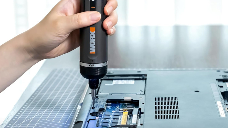 A Worx power screwdriver used to disassemble a laptop.
