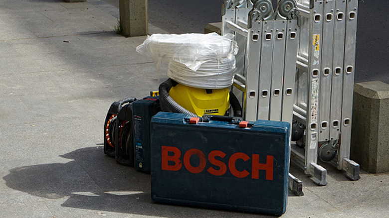 A worker using a band saw to cut a pipe