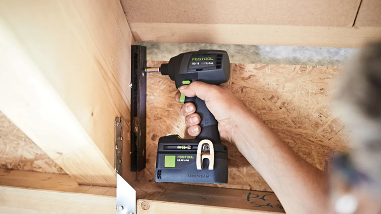 A Festool power drill screwing two pieces of wood together.